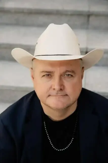 Close-up of a man wearing a cowboy hat, highlighting LGBTQ+ friendly content on Divine Magazine.
