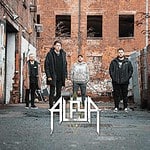 ALEYA band members standing outdoors in an urban alley with brick walls.