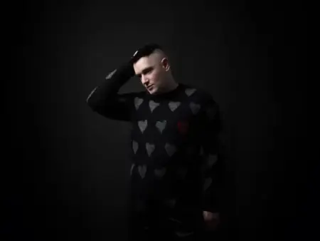 Andrew Spice – Pretty Demons (Remastered 2026) Portrait of Andrew Spice wearing a heart-patterned sweater against a dark background.