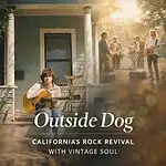 Young man playing acoustic guitar on porch during outdoor music event in California.