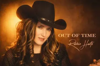Robbie Harte in cowboy hat holding guitar for country music promotion.