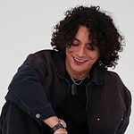 Frankie with curly hair smiling, celebrating new single "R0LL3RC0AST3R".